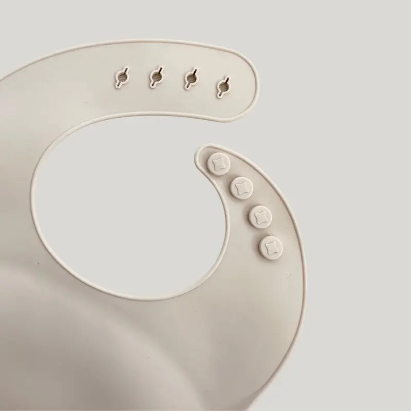 babador de silicone bege com bolso pega migalhas para bebê