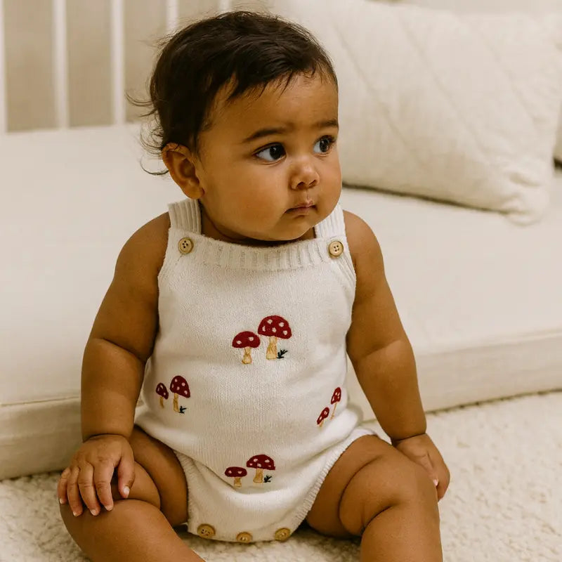 jardineira de tricot off white com estampa de cogumelos para bebê